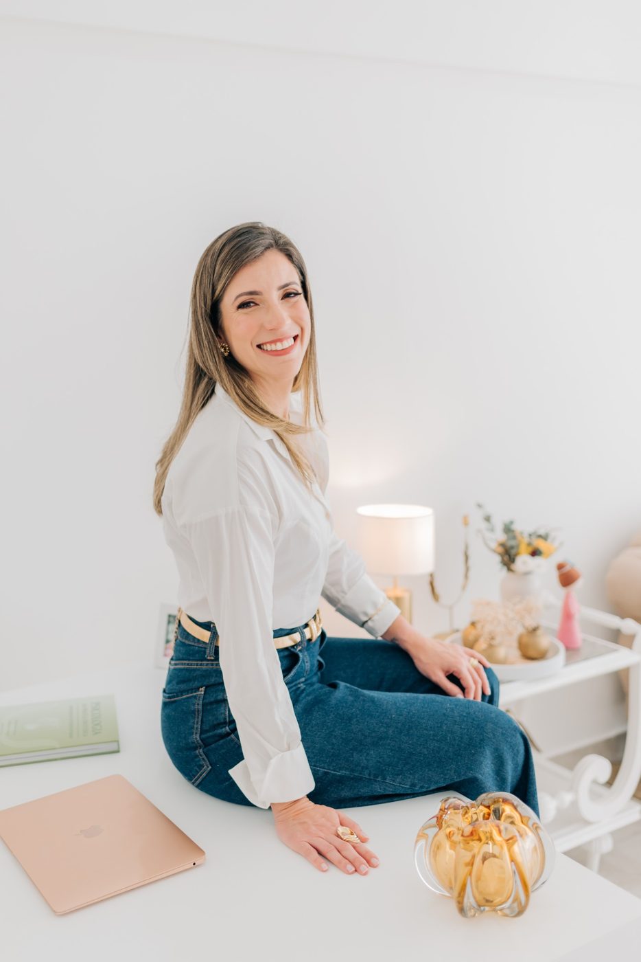 Carolina Ferraz sentada à mesa, sorrindo
